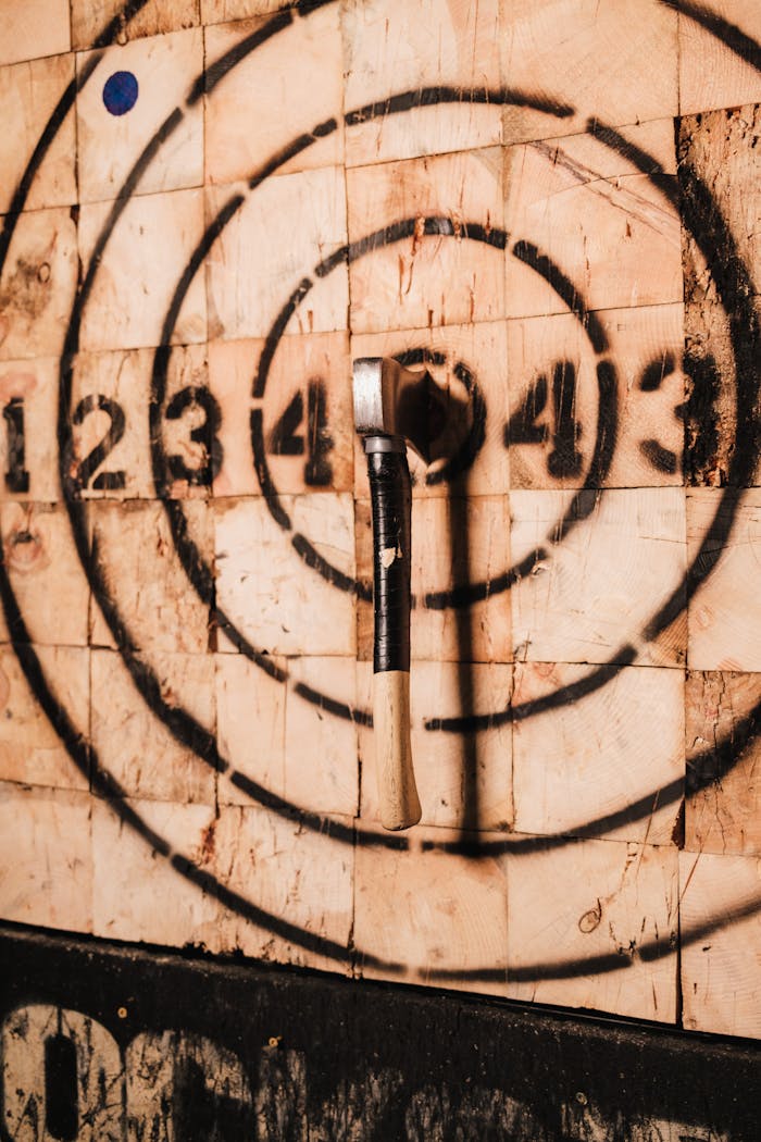 The Art of Drawing Readers In: Your attractive post title goes here Close-up of an axe embedded in a bullseye on a wooden target, capturing the sport of axe throwing.